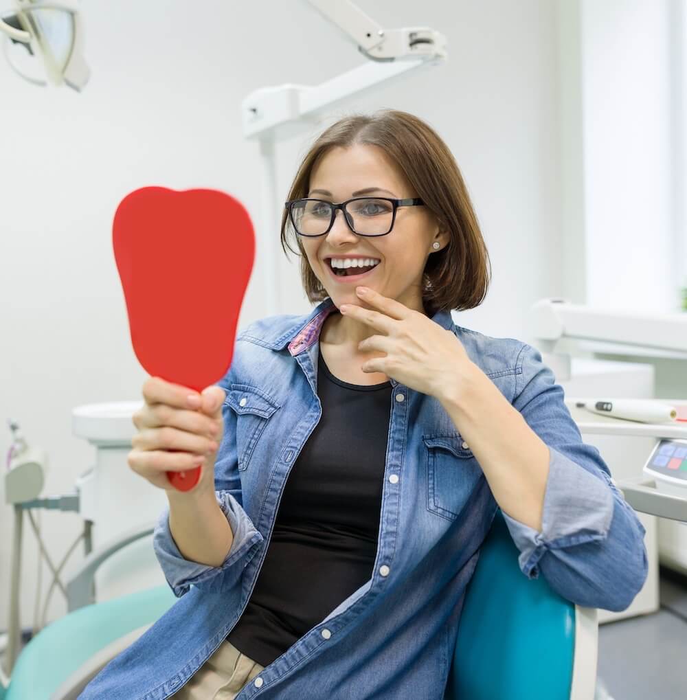 woman smiling after getting a dental implant